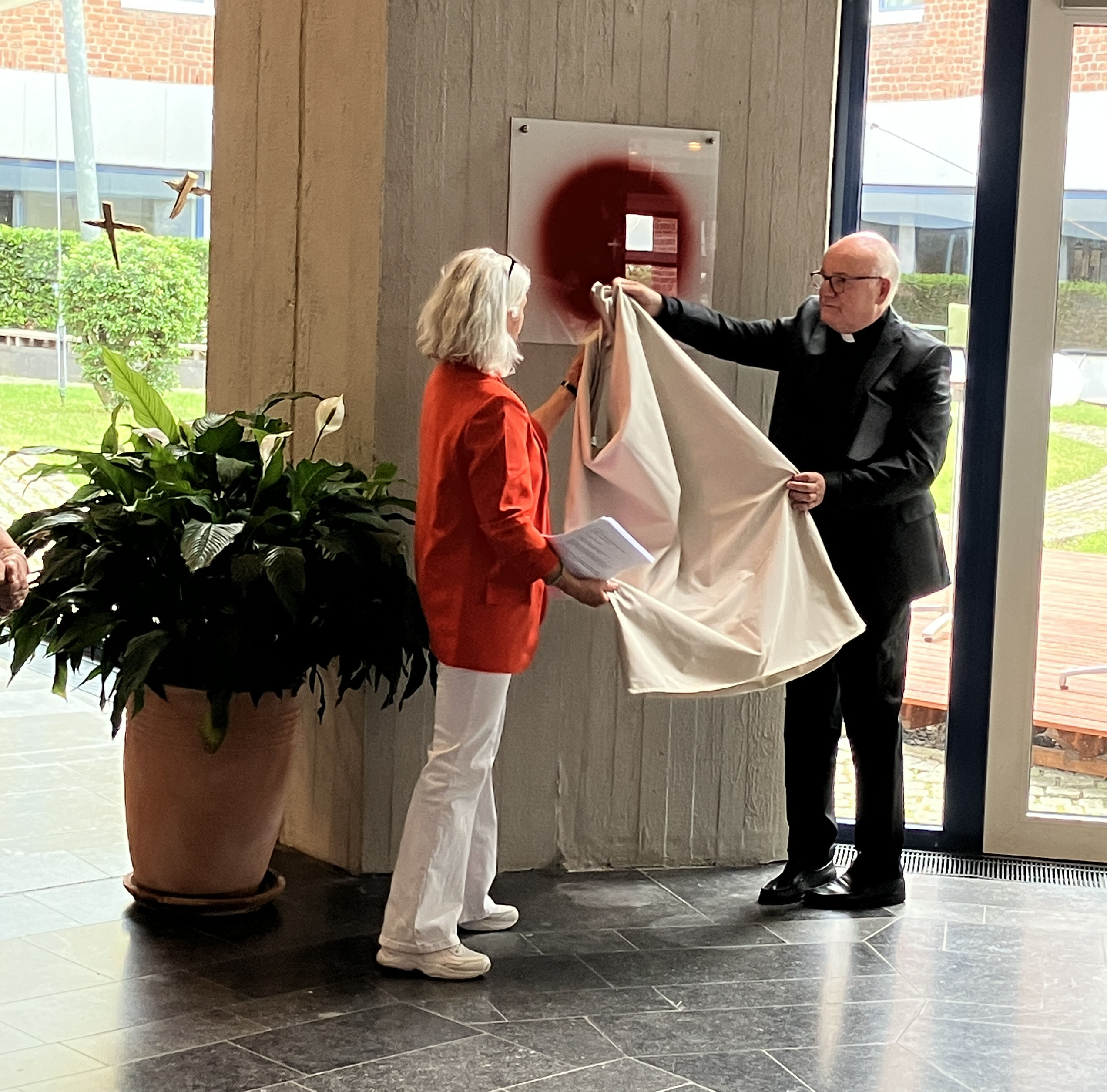 Professorin Dr. Stefanie Lieb, Studienleiterin für Kunst und Kultur und Akademiedirektor Monsignore Dr. Michael Menke-Peitzmeyer enthüllen den „Schmerzpunkt“ in der Katholischen Akademie Schwerte. Foto: Katholische Akademie Schwerte