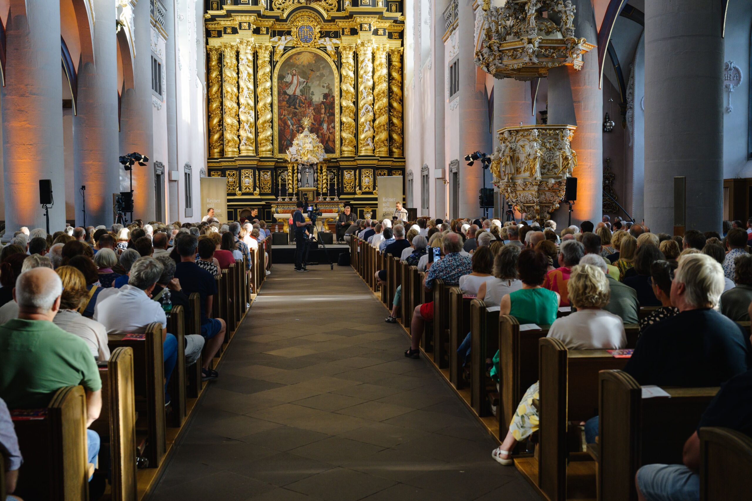 Aufnahme einer vollen Kirche. Im Altarraum ist eine Bühne ausgebaut.
