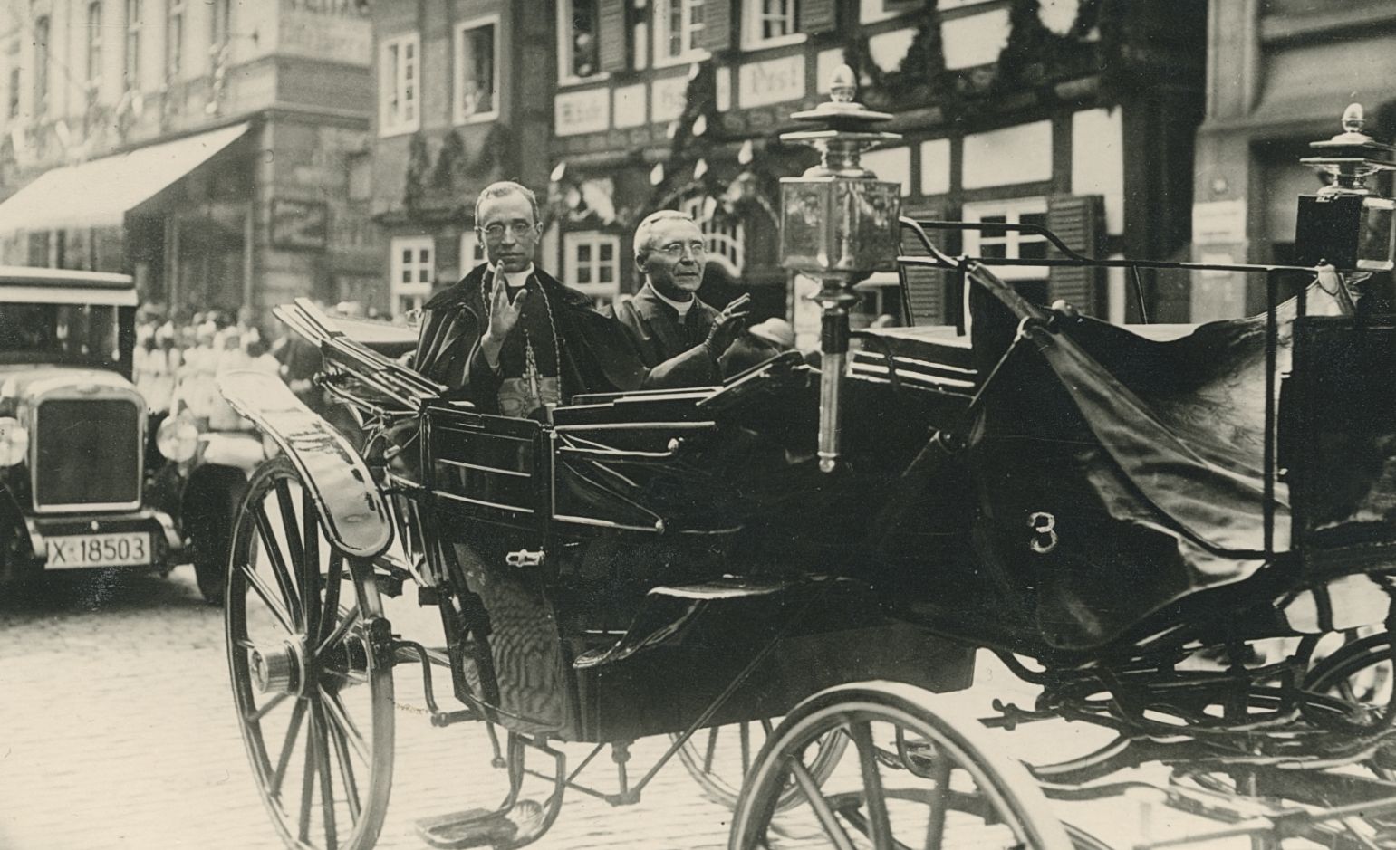Nuntius Eugenio Pacelli (l.) und Bischof Klein (r.) steigen am Westerntor vom Auto in die Kutsche um und fahren durch die Westernstraße. Das Auto folgt ihnen. (Erzbistumsarchiv Paderborn, C034 - Akten Metropolitankapitel 1945-1981, Nr. 18,3)