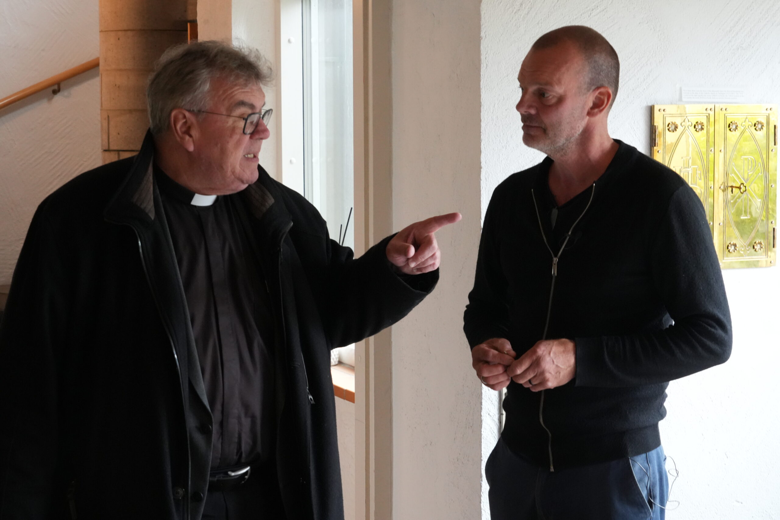 Bonifatiuswerk-Generalsekretär Msgr. Georg Austen mit dem Pfarrgemeinderatsvorsitzenden Eilif Brimheim, der das geplante barrierefreie Projekt erklärt (v.l.).