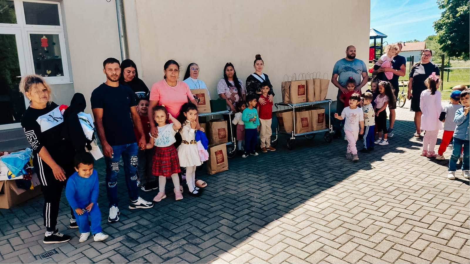 Familien bei der Übergabe der Glücklicht-Tüten