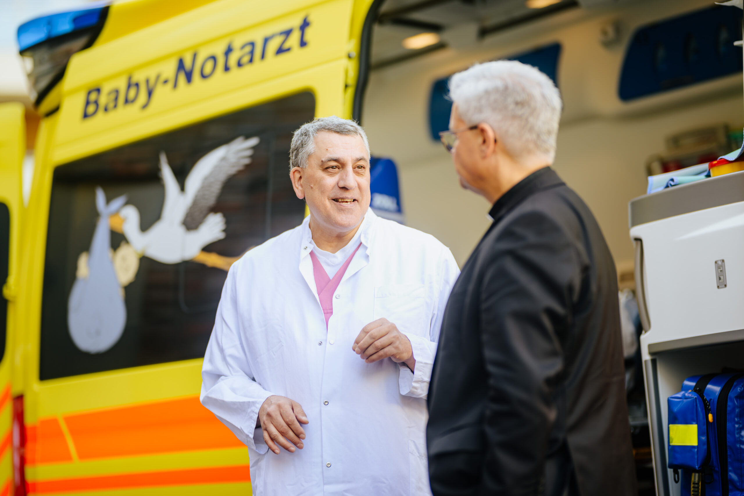 Dr. Bahman Gharavi, Chefarzt der Kinder- und Jugendklinik des Marien Hospital Witten, zeigt Erzbischof Dr. Udo Markus Bentz den Wagen des Projekts Baby-Notarzt.