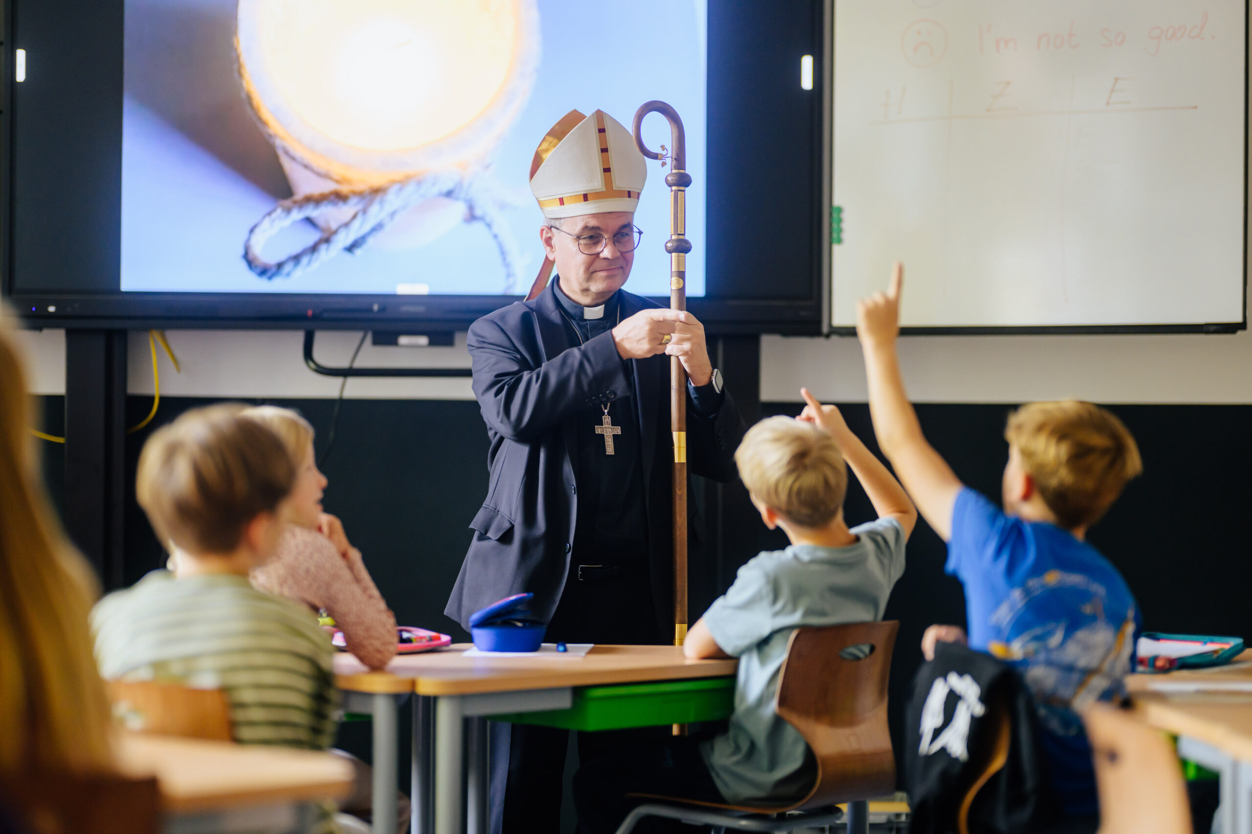 Große Neugierde, was ein Bischof so alles macht: Bei seinem Besuch der katholischen Grundschule an der Bergstraße in Herne kommt Erzbischof Dr. Udo Markus Bentz mit den Kindern ins Gespräch: über Gott und das, was sie bewegt.