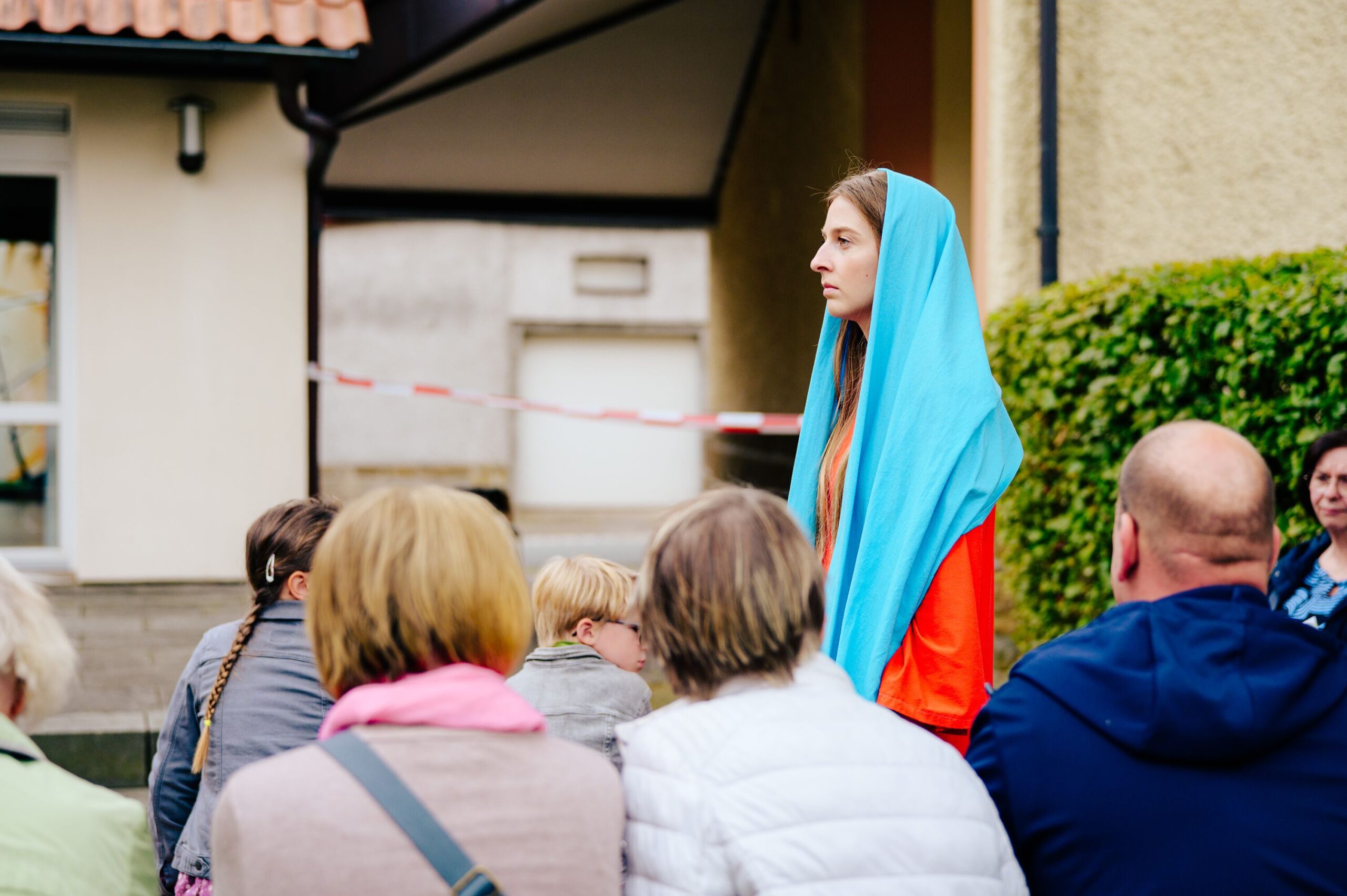 Von hinten zieht Maria durch die Besuchergruppe zu Elisabeth.
