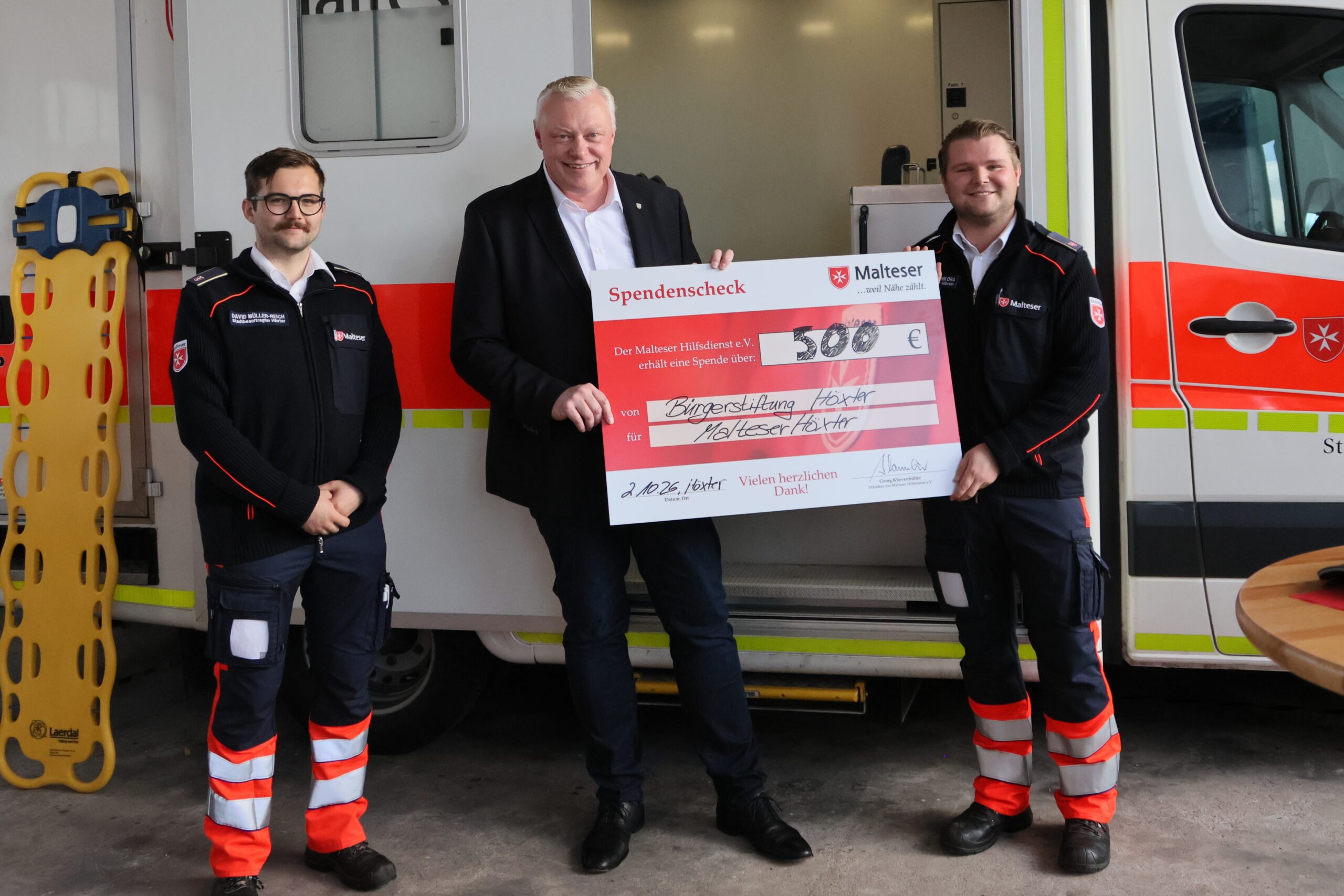 Übergabe symbolischer Spendenscheck für die neue Fahrtrage (v.l.n.r.): David Müller-Reich, Malteser Stadtbeauftragter, Bürgermeister Daniel Hartmann und Noah Finn Schikora, Malteser Geschäftsführer