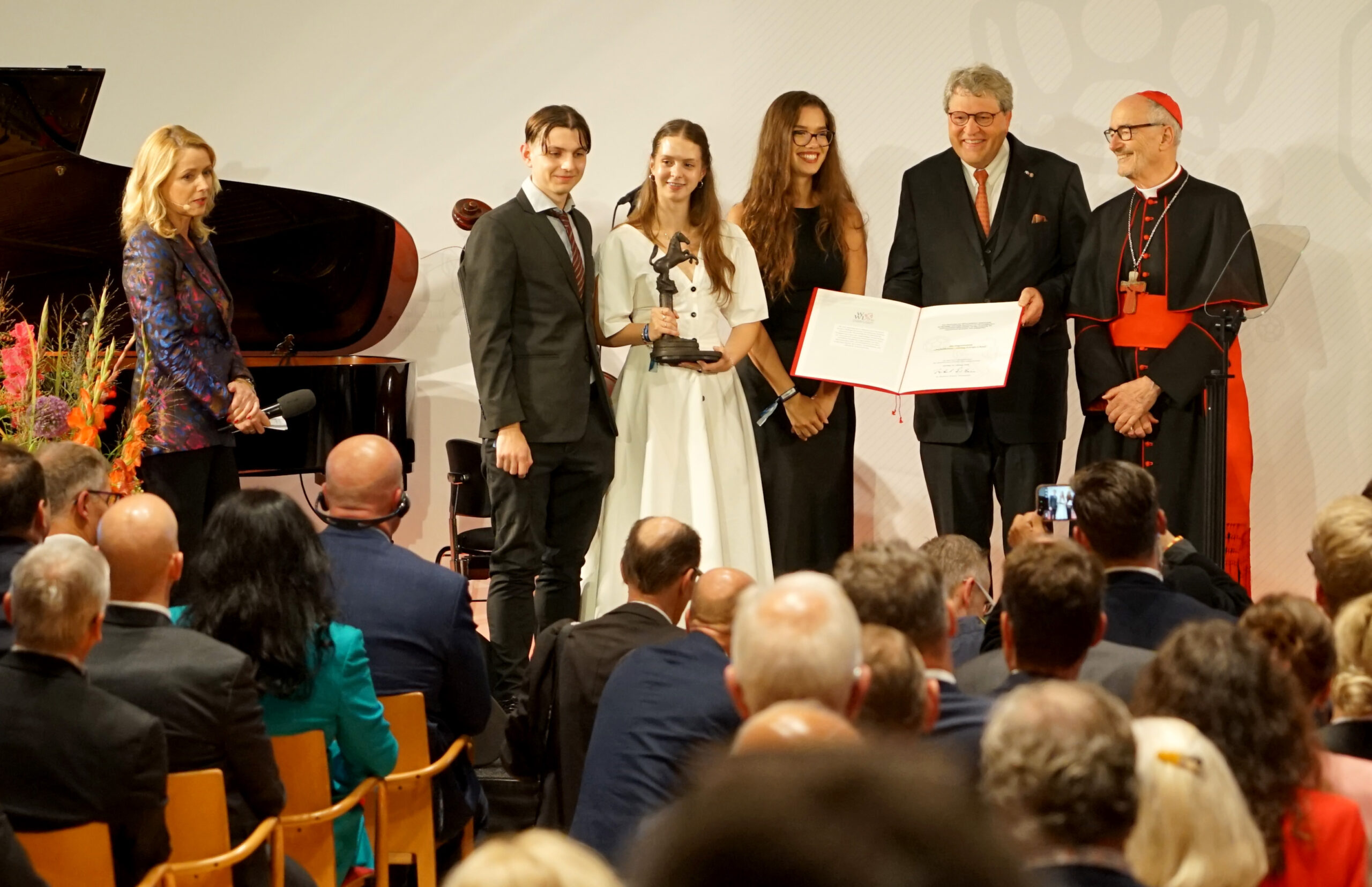 Drei Jugendliche aus Osteuropa nahmen für socioMovens Statue und Urkunde für den Jugendpreis des Westfälischen Friedens im Rathaus von Münster in Empfang. Hier mit Dr. Reinhard Zinkann, Vorstandsvorsitzender der ausrichtenden Wirtschaftlichen Gesellschaft für Westfalen und Lippe (WWL) und Laudator Kardinal Michael Czerny (rechts). Foto: Michael Bodin / Erzbistum Paderborn