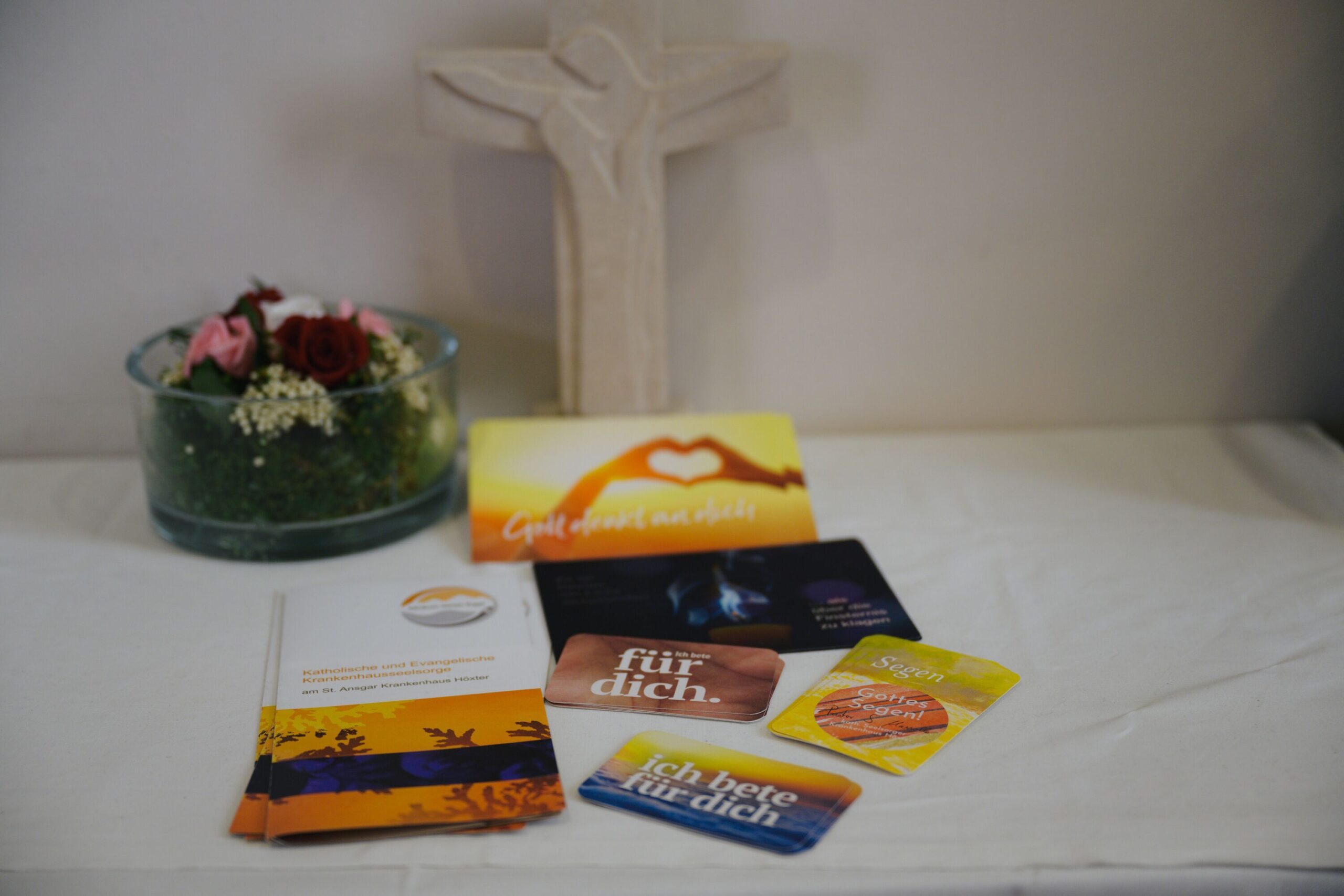 Nahaufnahme von einem Kreuz und verschiedenen christlichenPostkarten
