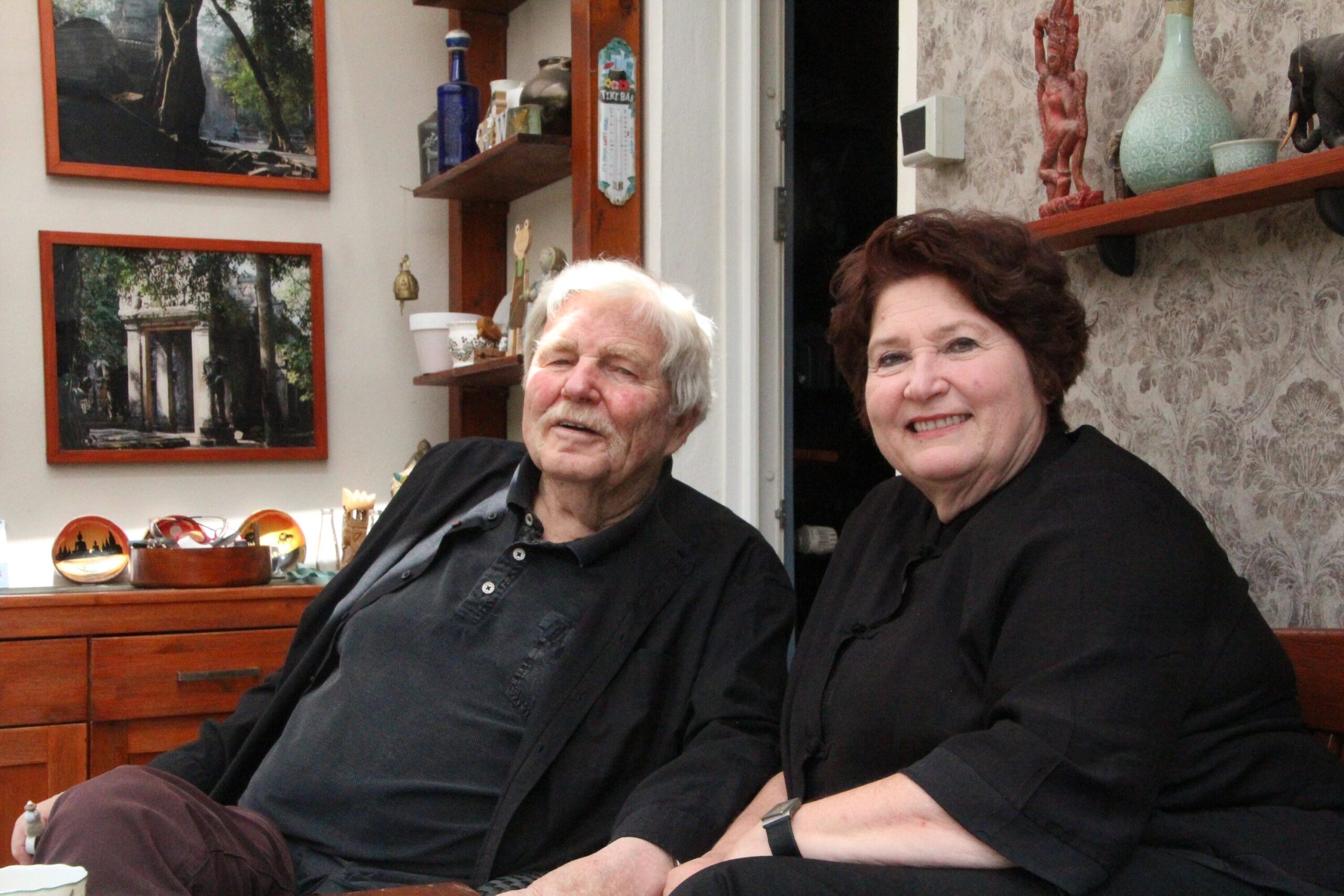 Peter und Anke Schanz sitzen in ihrem Wintergarten und lächeln in die Kamera.